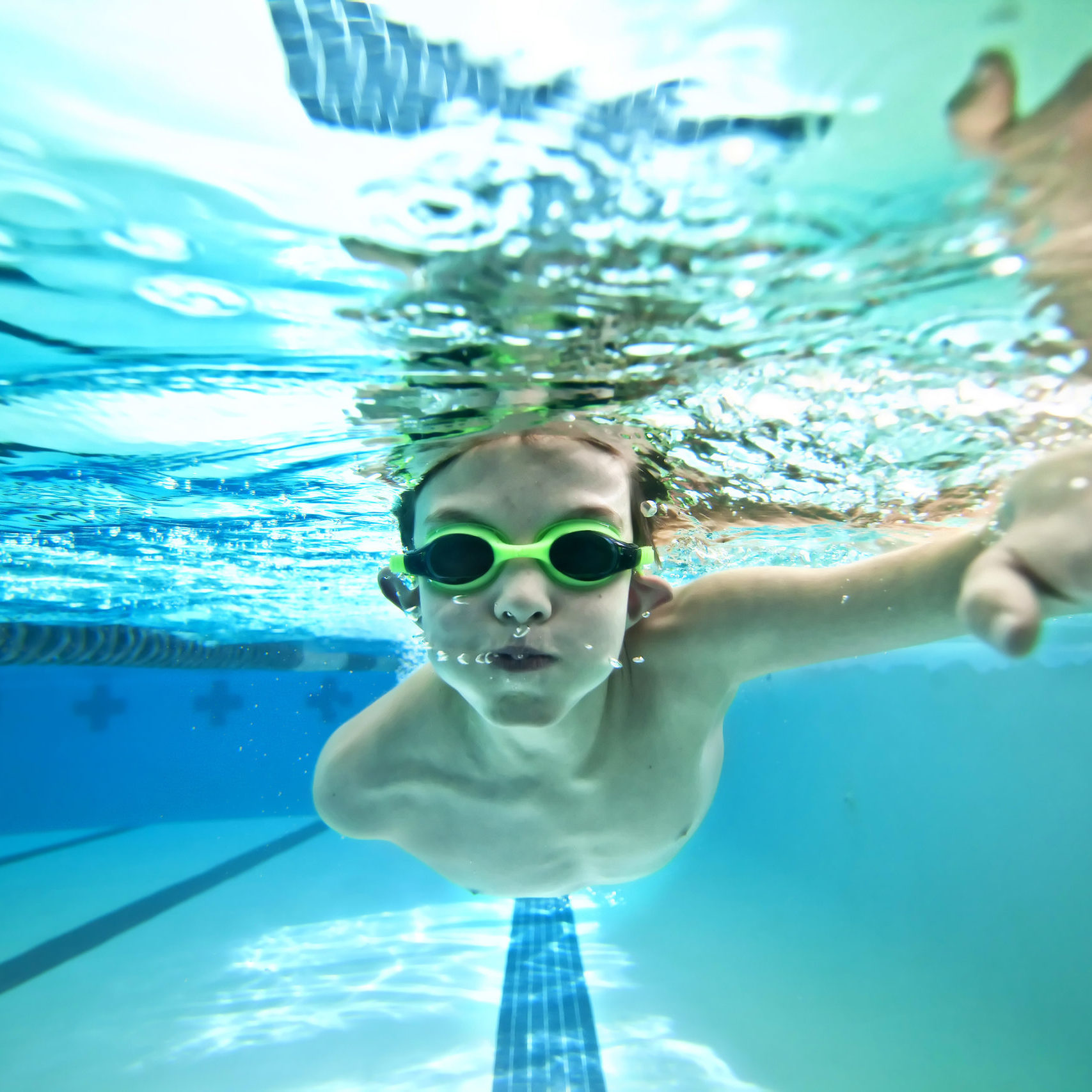underwater shot of boy swimming laps in pool